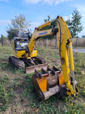 une pelleteuse jaune garée dans l'herbe
