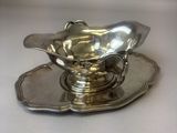 a silver plate with a saucer and a spoon on it