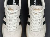 the white and black sneakers are on a black surface