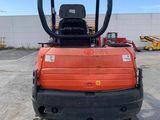 an image of a small orange tractor parked in a parking lot