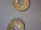 three gold buttons that are on a table