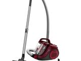 un aspirateur rouge est posé par terre à côté d'un autre aspirateur