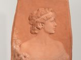 sculpture représentant une tête de femme posée sur une étagère blanche dans une pièce blanche