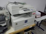 a stack of printers sitting on a table in a room