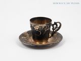 a cup and saucer on a saucer on a white surface