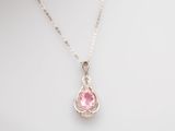 a pink crystal tear shaped pendant on a silver chain