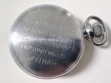 a silver pocket watch on a white surface