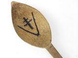 a wooden spoon with a black design on it