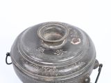 an old metal pot with a handle on a white surface
