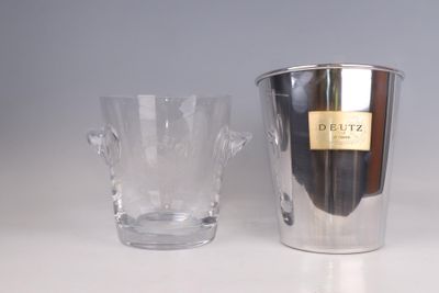a silver ice bucket and a clear glass on a table
