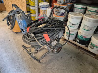 un chariot muni d'un tuyau, dans un garage