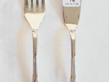 deux fourchettes et un couteau sur une table blanche