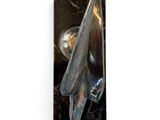 a metal object on a black surface with a light in the background