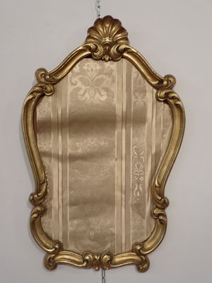 un miroir doré accroché au mur de la pièce