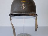 a helmet with an anchor on it sitting on a stand