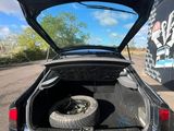 a car with its trunk open on the side of the road