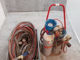 deux types différents de bouteilles de gaz et de tuyaux posés par terre