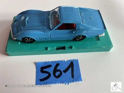 une petite voiture bleue posée sur un plateau vert
