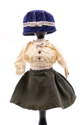 une poupée qui porte une robe et un chapeau
