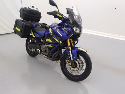 une moto bleue et jaune garée dans une pièce