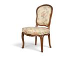 une image d'une chaise en bois dont l'assise est recouverte d'un rembourrage floral