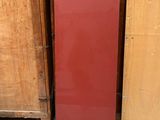a red refrigerator sitting in a room next to a stack of wooden crates