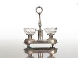 un bougeoir en argent sur lequel sont posées trois bougies en cristal