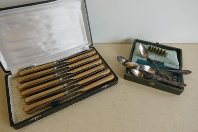 Plusieurs cuillères se trouvent dans un étui posé sur une table.