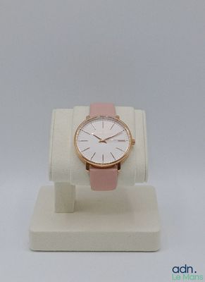 the watch is sitting on a display stand on a white surface