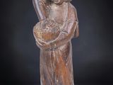 carved figurine of a man holding a basket of fruit