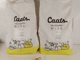 deux sacs de litière pour chat posés sur un plan de travail blanc