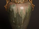 a vase that is sitting on a table in front of a black background