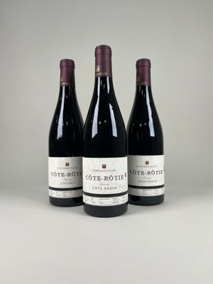 three bottles of red wine are lined up on a table