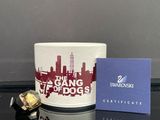 une tasse blanche ornée d'un motif rouge et blanc, à côté d'une boîte bleue