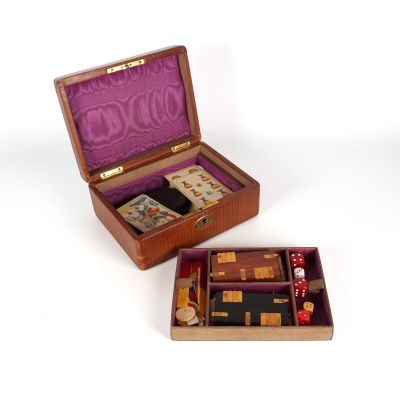 une petite boîte en bois contenant des dés et des cartes