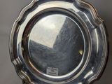 silver plate with a scalloped edge on a gray background