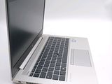 a silver laptop with a black keyboard on a white surface
