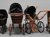 three baby strollers sitting next to each other on a white surface