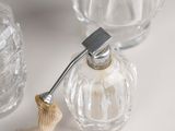 a glass bottle with a metal handle and a glass jar with a rope on it
