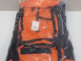 un sac à dos orange et noir, emballé dans du plastique, posé sur une table