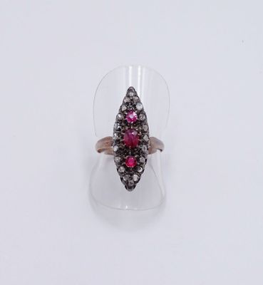 un gros plan d'une bague sertie d'un diamant rose et blanc posée sur une surface transparente