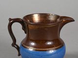 a brown and blue pitcher sitting on a table