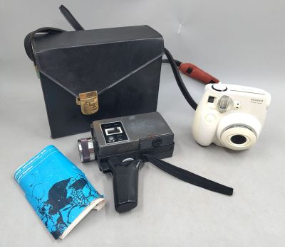 un appareil photo, un livre et un étui à appareil photo posés sur une table