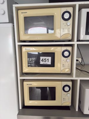 three microwaves stacked on top of each other in the kitchen