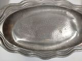 a silver plate with a wavy edge on a table