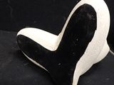pair of black and white slippers sitting on top of a black surface
