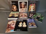 several books on a table with pictures of dolls on them