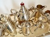 a silver tray with a silver tea set on it