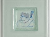 a glass plate with a drawing of a man holding a hair brush