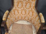 an old chair with a yellow and brown upholstered seat